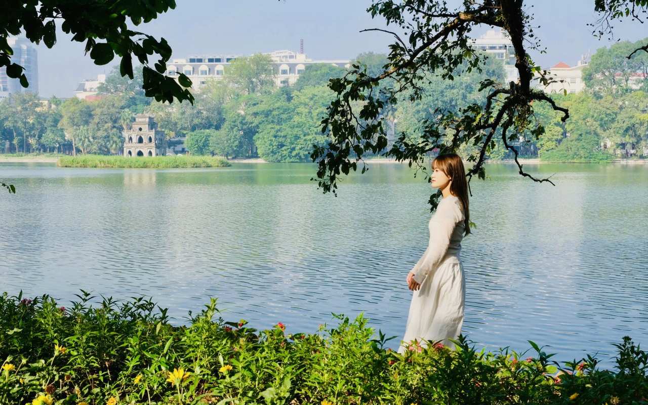 Hồ Hoàn Kiếm Hà Nội: Cẩm nang du lịch ăn gì, chơi gì 2026 9 Du khách check-in bên Hồ Hoàn Kiếm